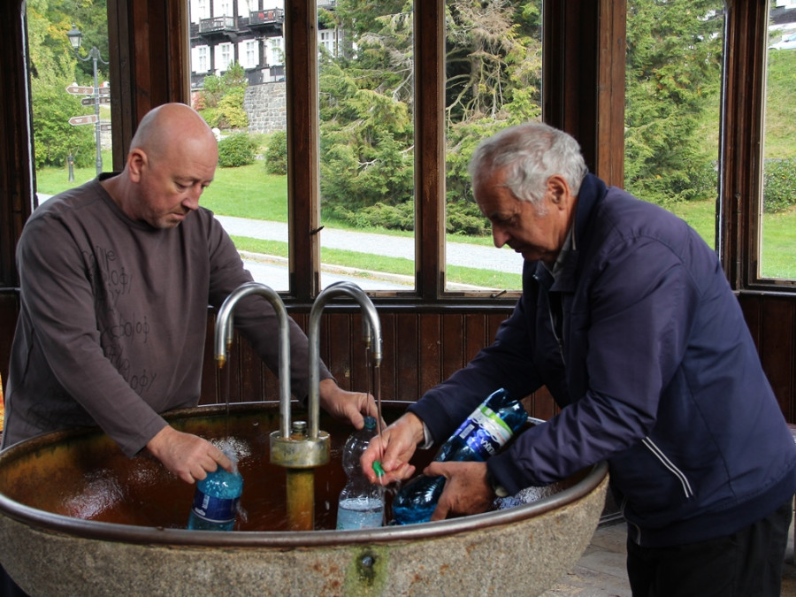 Mannen vullen flessen met gezond water Mannen vullen flessen met gezond water